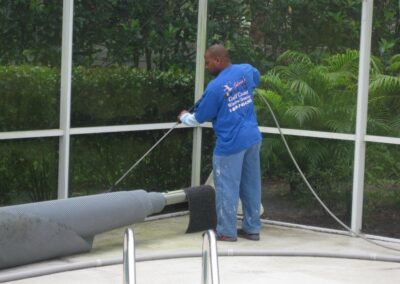 A man in blue shirt cleaning a pipe.