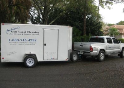 A truck pulling a trailer behind it on the street.