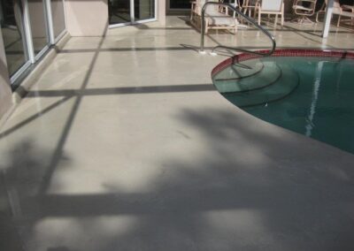 A pool with a chair and table in the background.