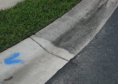 A sidewalk with blue paint on the side of it.
