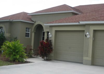 A house with a garage and driveway in front of it.